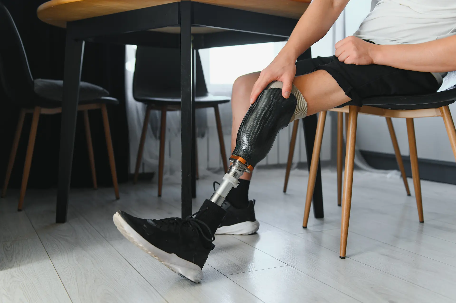 Person with prosthetic leg sitting at table