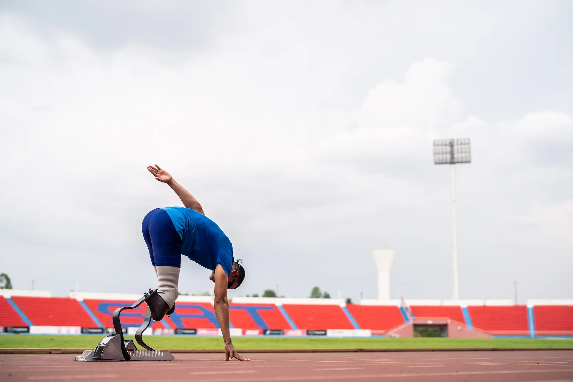 Athlete with prosthetics on track, preparing to run.