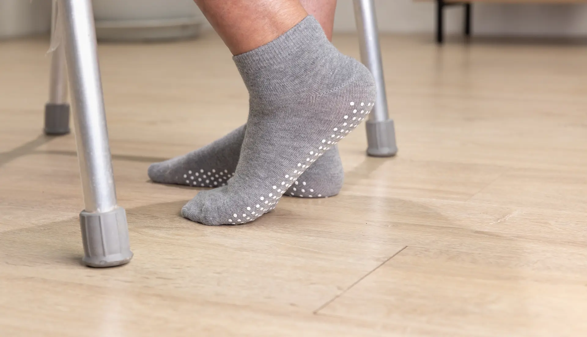4-shutterstock_2449545485 Gray non-slip socks on wood floor near walker.